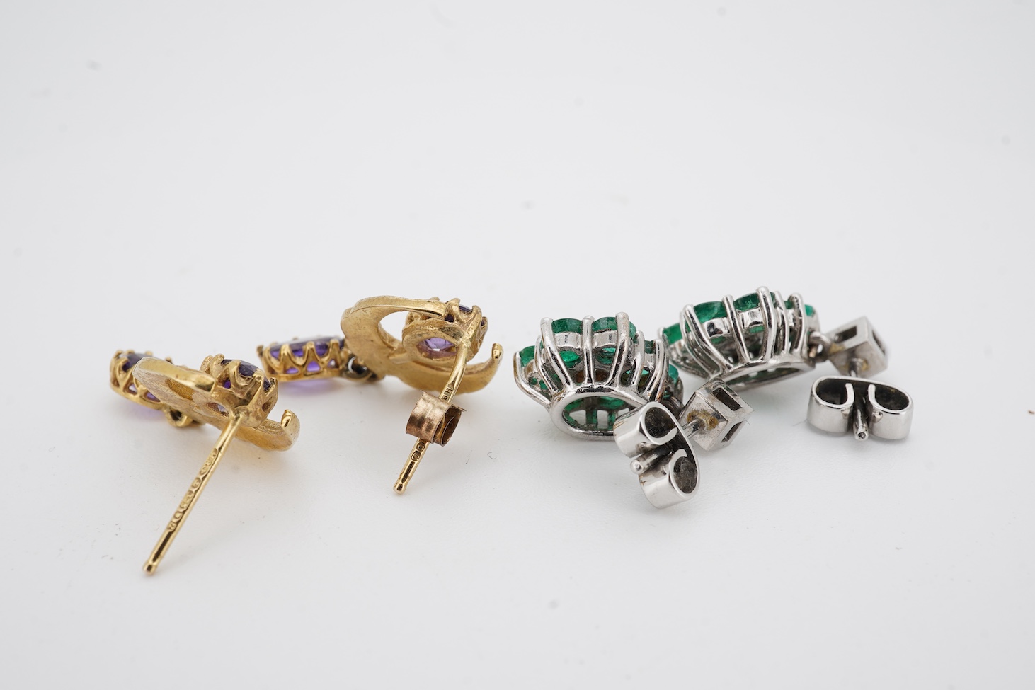 A pair of mid to late 20th century white metal, emerald and diamond cluster set drop earrings, drop 16mm, together with a pair of 9ct gold, amethyst and seed pearl set crescent drop earrings.